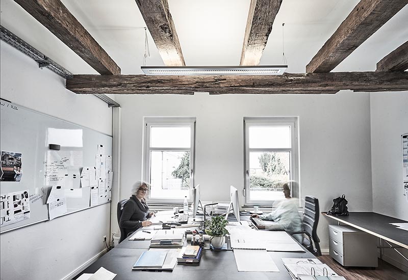 Architekturbüro mit Architekten, die an Schreibtischen arbeiten