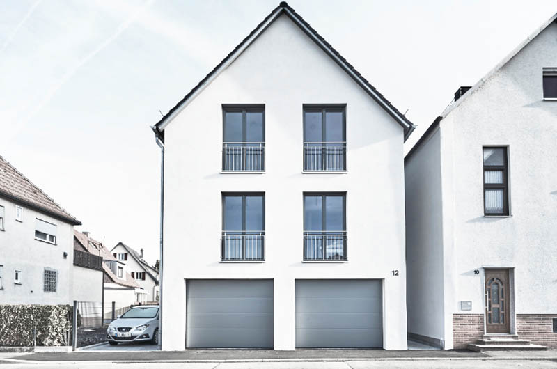 Neubau modernes, weißes Zweifamilienhaus mit zwei itegrierten Garagen und Satteldach Außenansicht frontal
